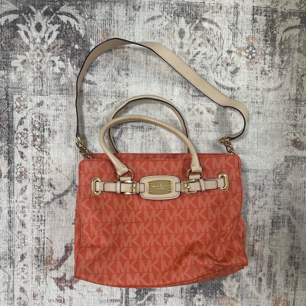 Michael Kors tangerine medium sized purse with shoulder strap and handles.